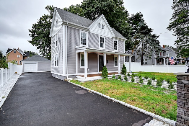 view of front of property with a garage, an outbuilding, a porch, and a front yard