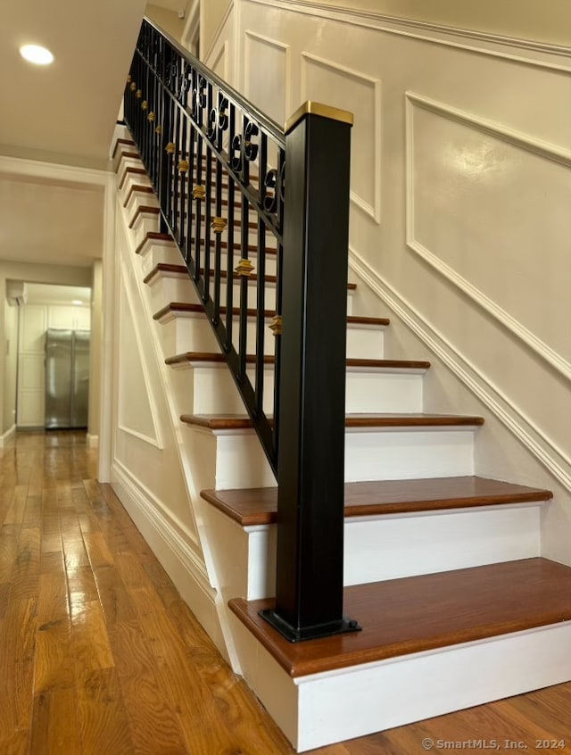 staircase with hardwood / wood-style floors