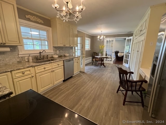 kitchen with appliances with stainless steel finishes, a wealth of natural light, pendant lighting, and an inviting chandelier