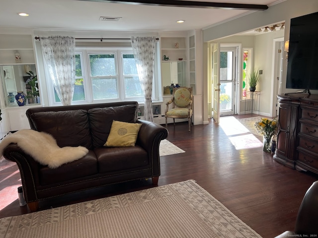 living room featuring a wealth of natural light, crown molding, built in shelves, and hardwood / wood-style flooring