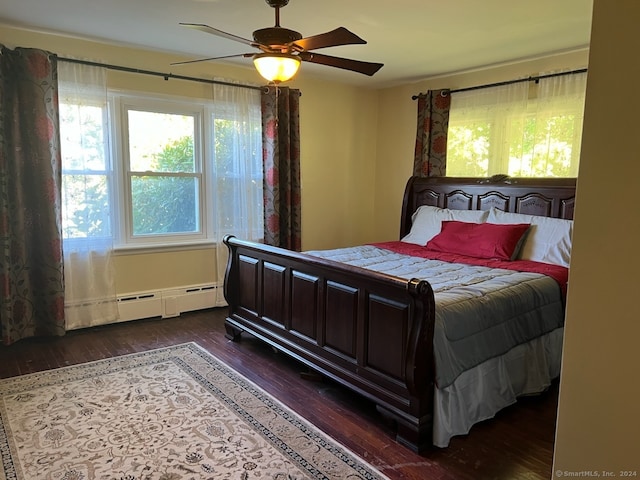 bedroom with a baseboard heating unit, ceiling fan, and dark hardwood / wood-style floors