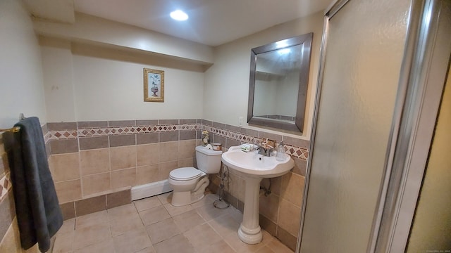 bathroom with tile walls, toilet, a baseboard radiator, and tile patterned floors