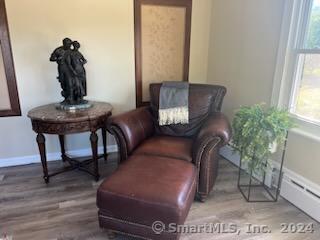 living area featuring baseboard heating and wood-type flooring