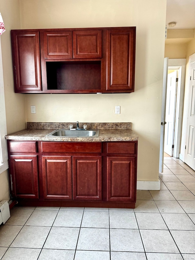 kitchen with sink, light tile patterned floors, and a baseboard heating unit