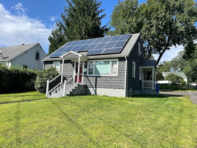 bungalow-style house with a front lawn and solar panels