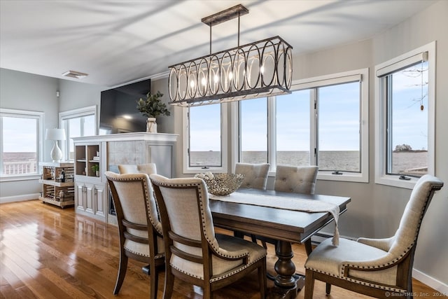 dining room featuring an inviting chandelier, hardwood / wood-style floors, and a healthy amount of sunlight