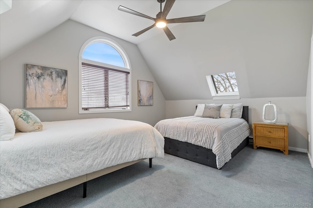 carpeted bedroom featuring vaulted ceiling with skylight and ceiling fan