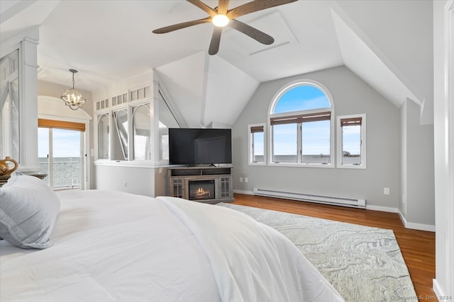 bedroom featuring multiple windows, hardwood / wood-style floors, lofted ceiling, and a baseboard radiator