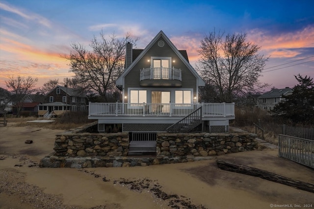 back house at dusk with a wooden deck