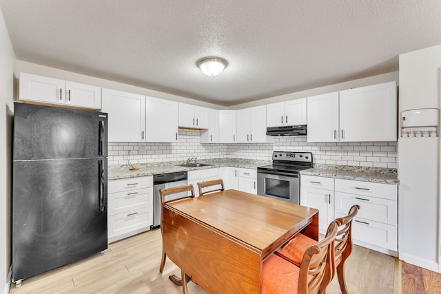 kitchen featuring light wood-type flooring, stainless steel appliances, tasteful backsplash, and white cabinets