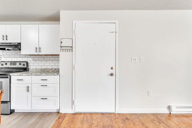 interior space featuring decorative backsplash, electric range, ventilation hood, light hardwood / wood-style floors, and a baseboard heating unit