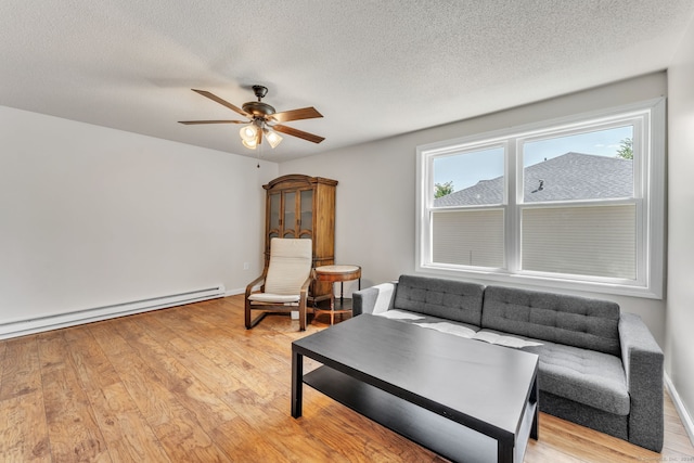 living room featuring a textured ceiling, ceiling fan, light wood-type flooring, and a baseboard radiator