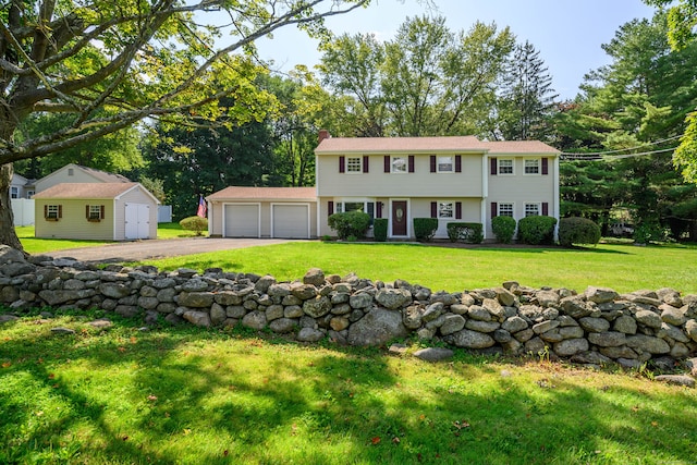 colonial home featuring an outbuilding and a front yard