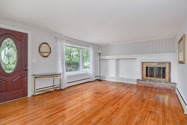 interior space featuring light hardwood / wood-style flooring, a brick fireplace, and baseboard heating