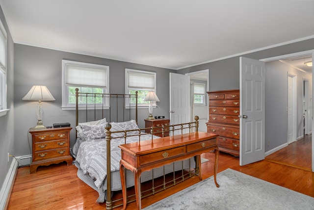 bedroom featuring light hardwood / wood-style flooring, baseboard heating, and ornamental molding