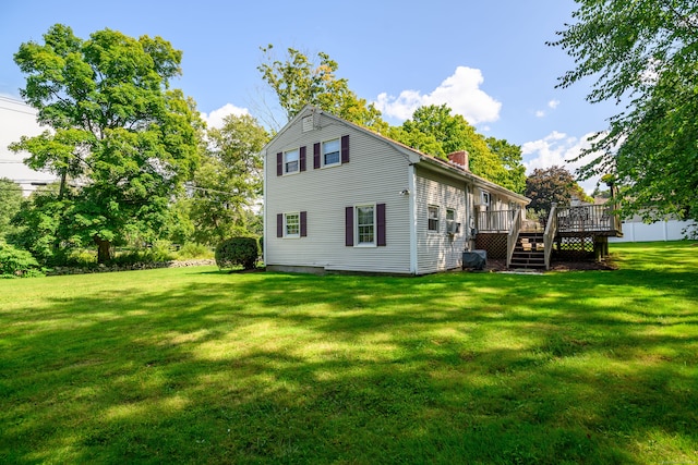 rear view of house featuring a deck and a yard