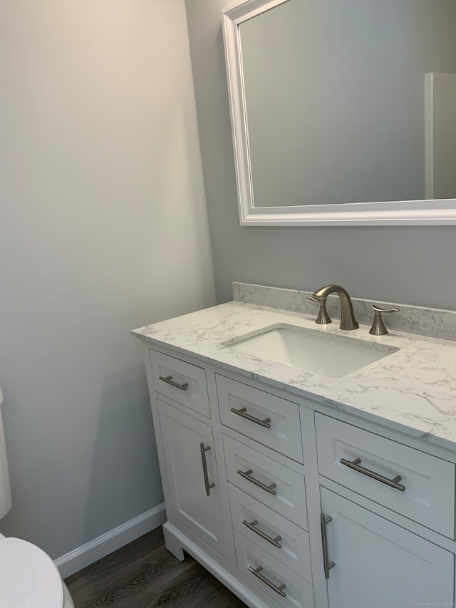 bathroom featuring toilet, hardwood / wood-style floors, and vanity