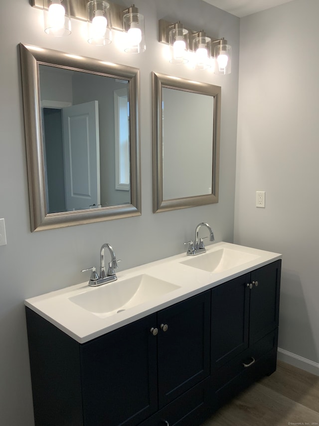 bathroom featuring double sink vanity and wood-type flooring