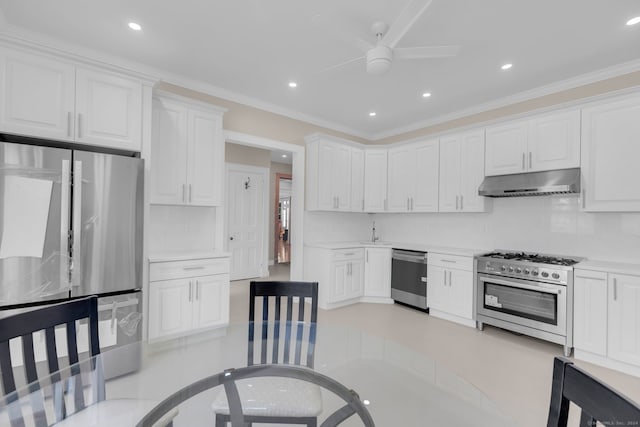 kitchen featuring stainless steel appliances, white cabinetry, ornamental molding, light tile patterned floors, and ceiling fan