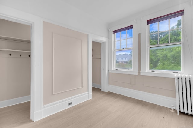 unfurnished bedroom featuring light hardwood / wood-style floors and radiator