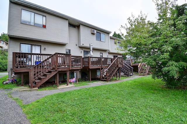 back of property with a wooden deck and a lawn