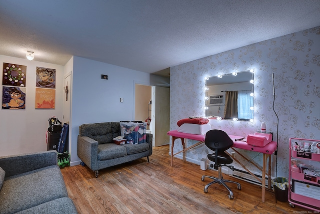 office area with hardwood / wood-style floors, a textured ceiling, and a wall mounted AC