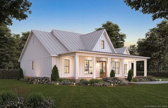 modern farmhouse with covered porch and a yard