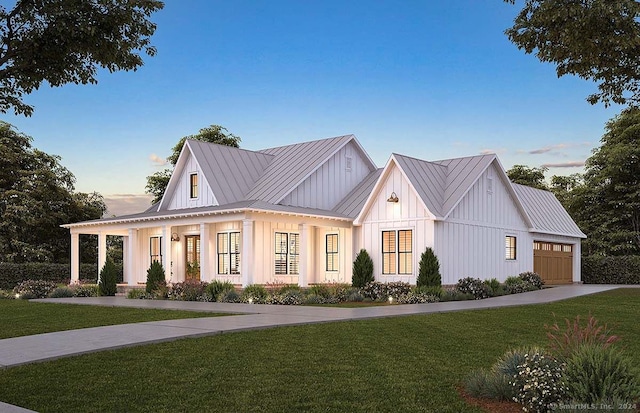 modern inspired farmhouse with covered porch, a garage, and a yard