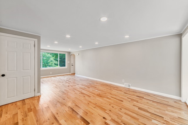 empty room featuring ornamental molding and light hardwood / wood-style flooring