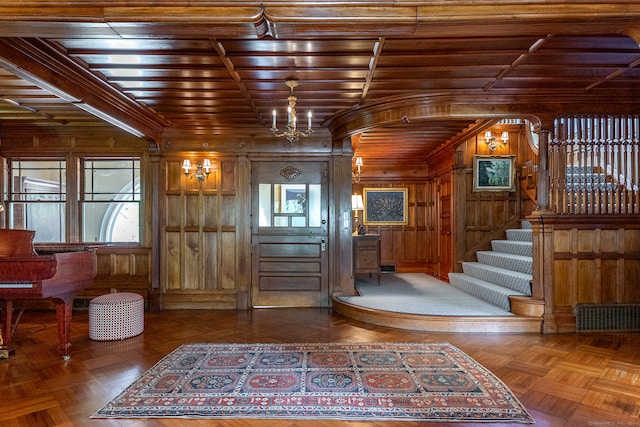 entryway featuring wood walls, parquet floors, and wooden ceiling