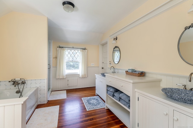 bathroom with vanity, vaulted ceiling, hardwood / wood-style flooring, and shower with separate bathtub