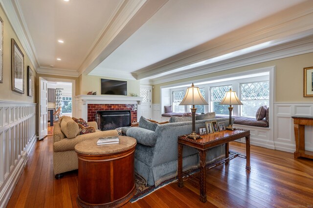 living room featuring ornamental molding, dark hardwood / wood-style floors, and a brick fireplace