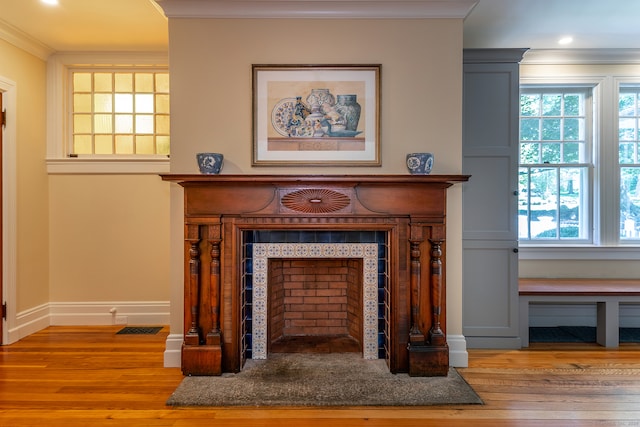 details with ornamental molding, a fireplace, and hardwood / wood-style flooring