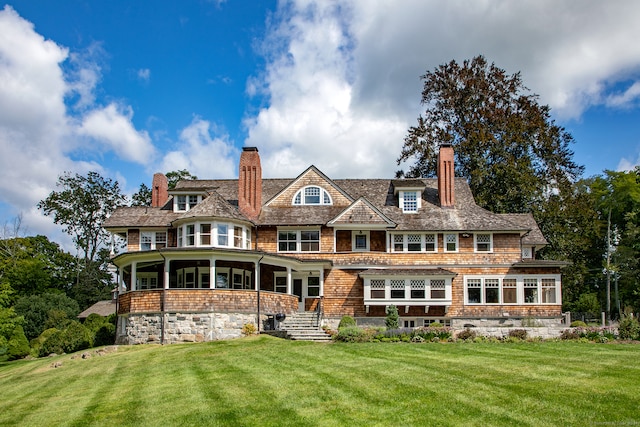 rear view of property with a lawn