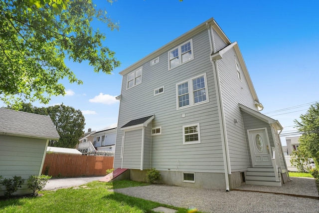 back of property featuring entry steps and fence