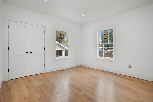 unfurnished bedroom featuring visible vents, baseboards, light wood-style flooring, a closet, and recessed lighting