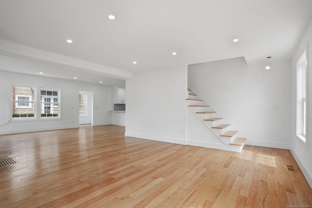 unfurnished living room with stairs, recessed lighting, visible vents, and light wood-style floors