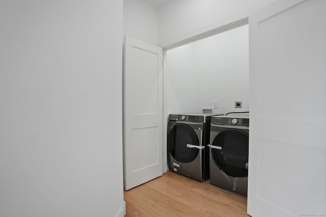 laundry area featuring light wood-type flooring, laundry area, and washing machine and dryer