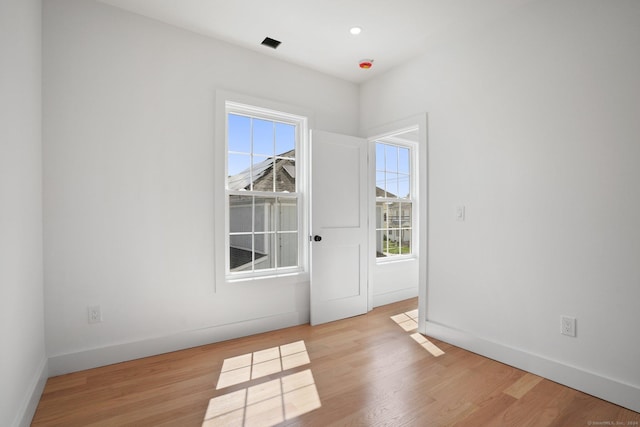 empty room with light wood finished floors and baseboards