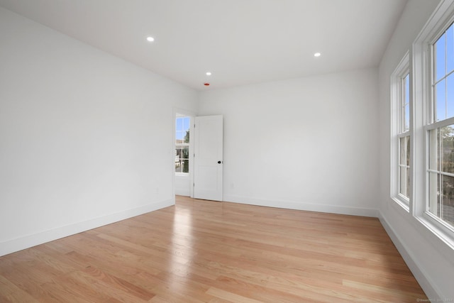 empty room with recessed lighting, light wood-style flooring, and baseboards