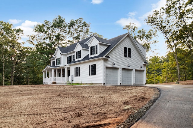 view of home's exterior with a garage and a porch