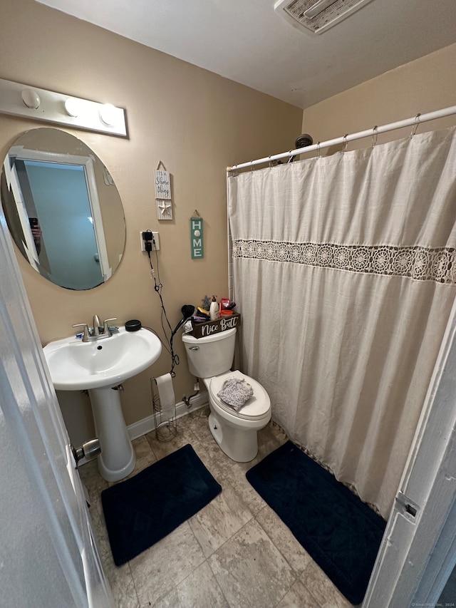 bathroom featuring sink, toilet, a shower with shower curtain, and tile patterned floors