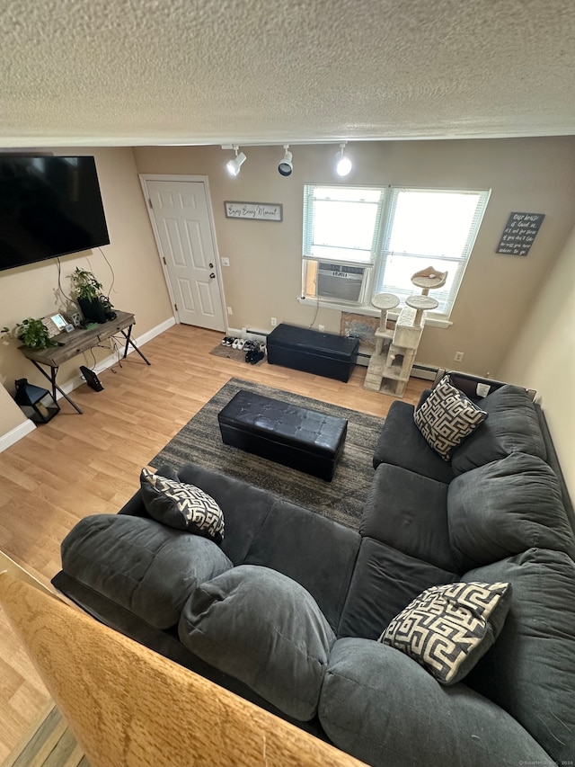 living room with wood-type flooring, a textured ceiling, and cooling unit