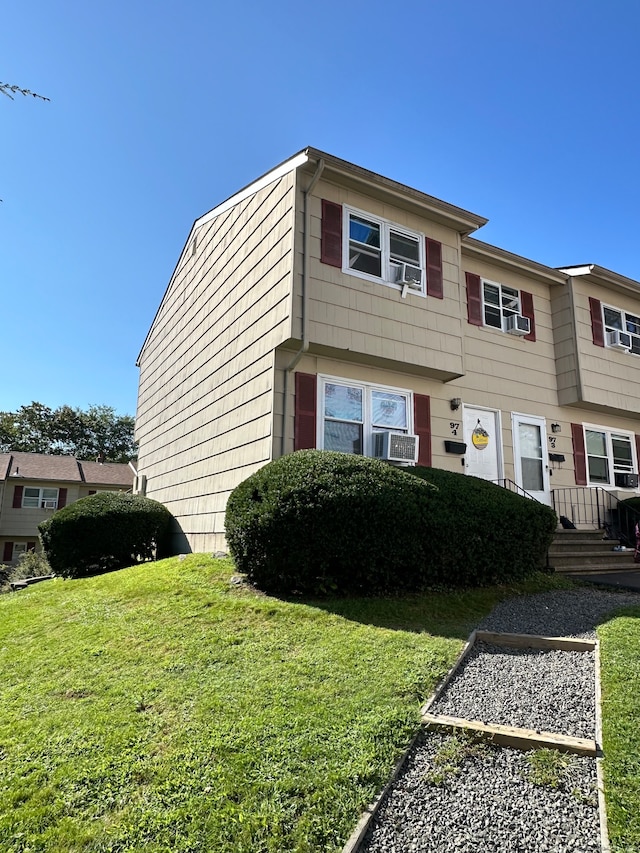 view of front of house with a front yard and cooling unit