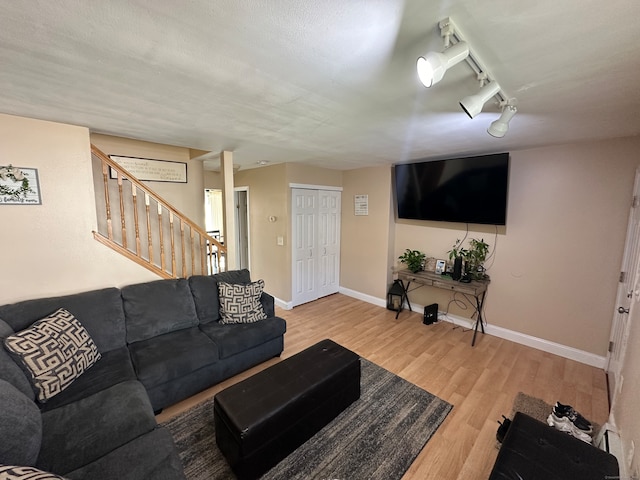 living room with light wood-type flooring and track lighting