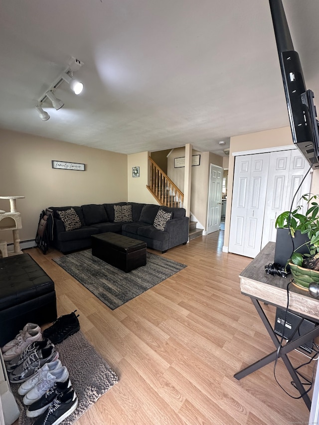 living room featuring light hardwood / wood-style floors, baseboard heating, and rail lighting