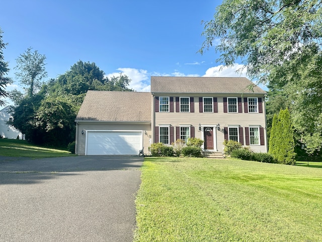 colonial home with a garage and a front yard