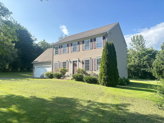 colonial home featuring a garage and a front yard