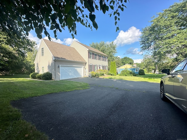 view of side of property with a lawn and a garage