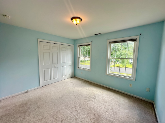 unfurnished bedroom featuring a closet and light carpet